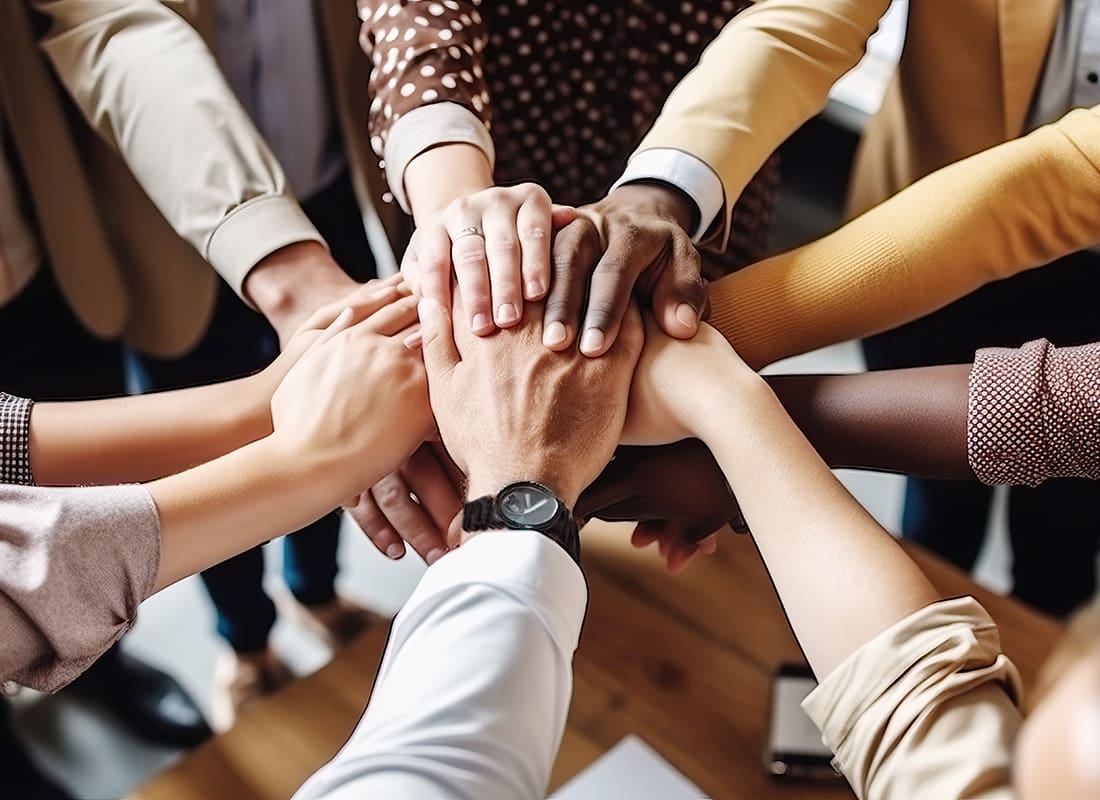 Service Center - Closeup View of a Group of Employees Stacking Their Hands on Top of Each Other to Celebrate Teamwork