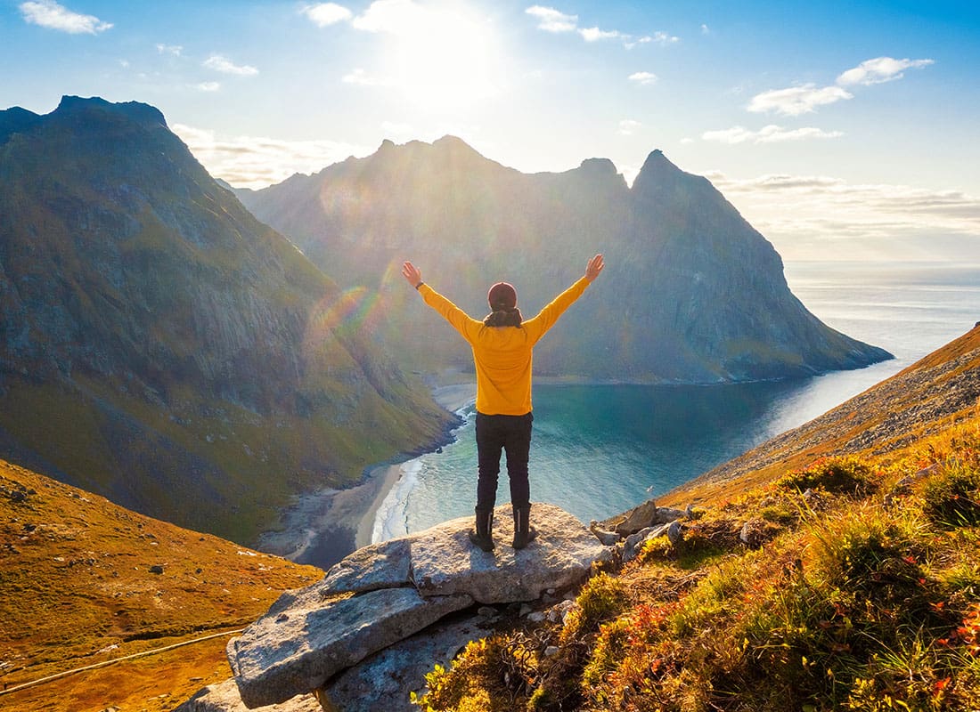 We Are Independent - Rear View of a Cheerful Man Putting his Hands Up in the Air While Looking Out at the Views on Top of a Cliff